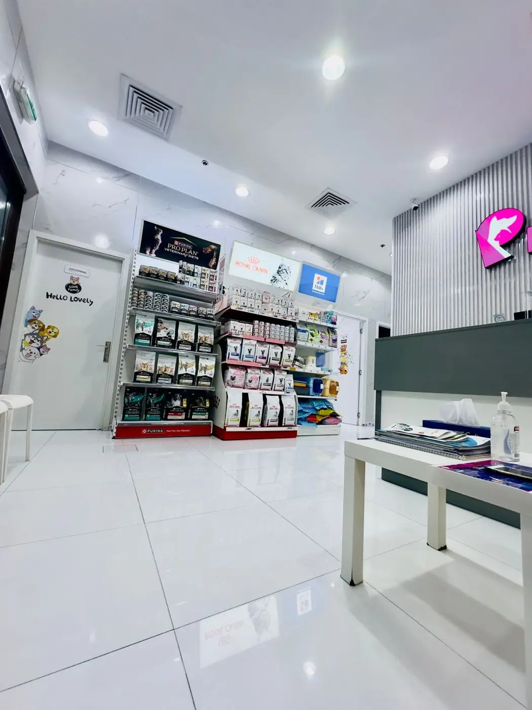 Wide view of bright lobby with retail food shelves, display table and glossy floor - no people